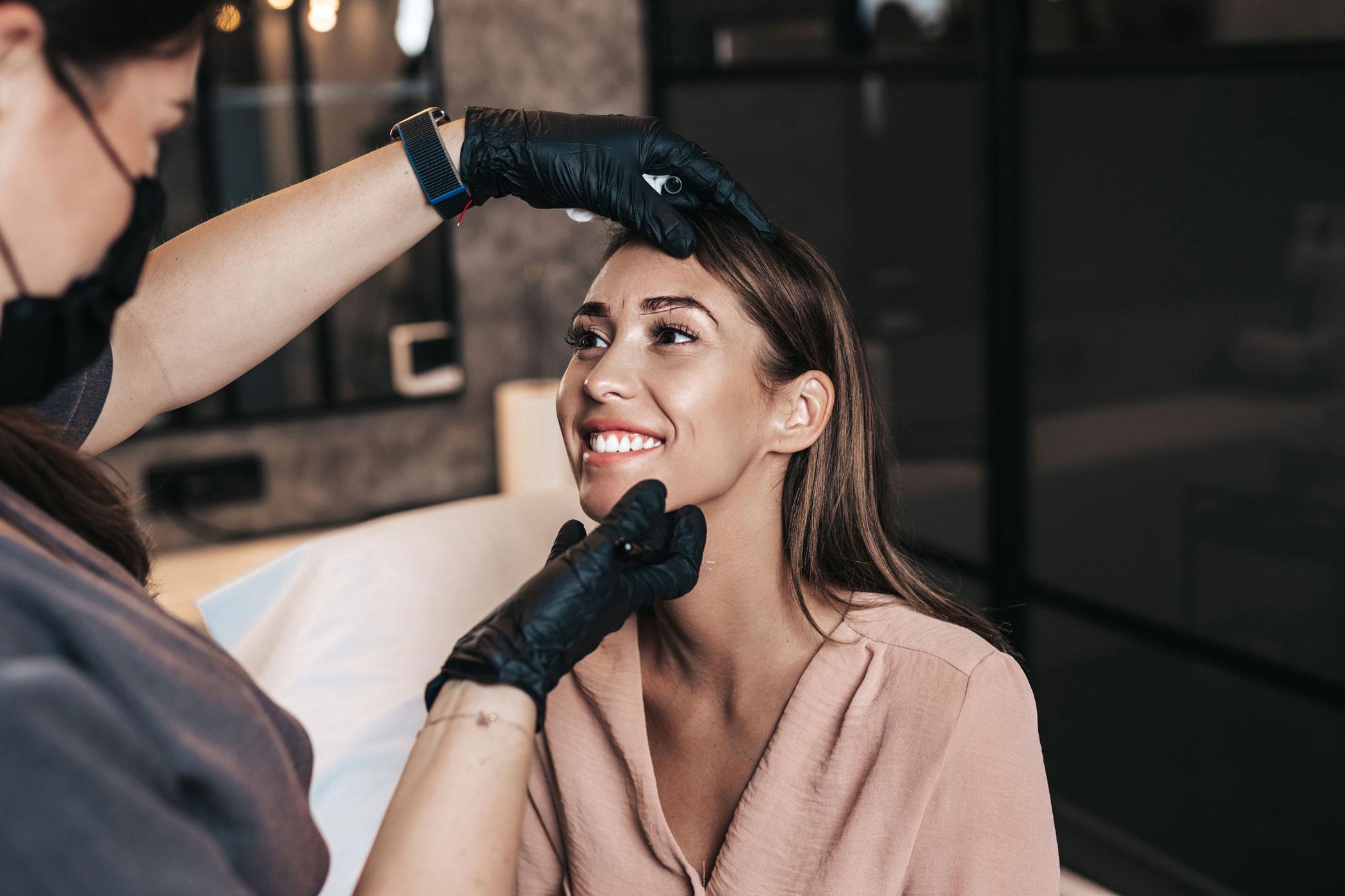 Smiling client with a permanent makeup artist