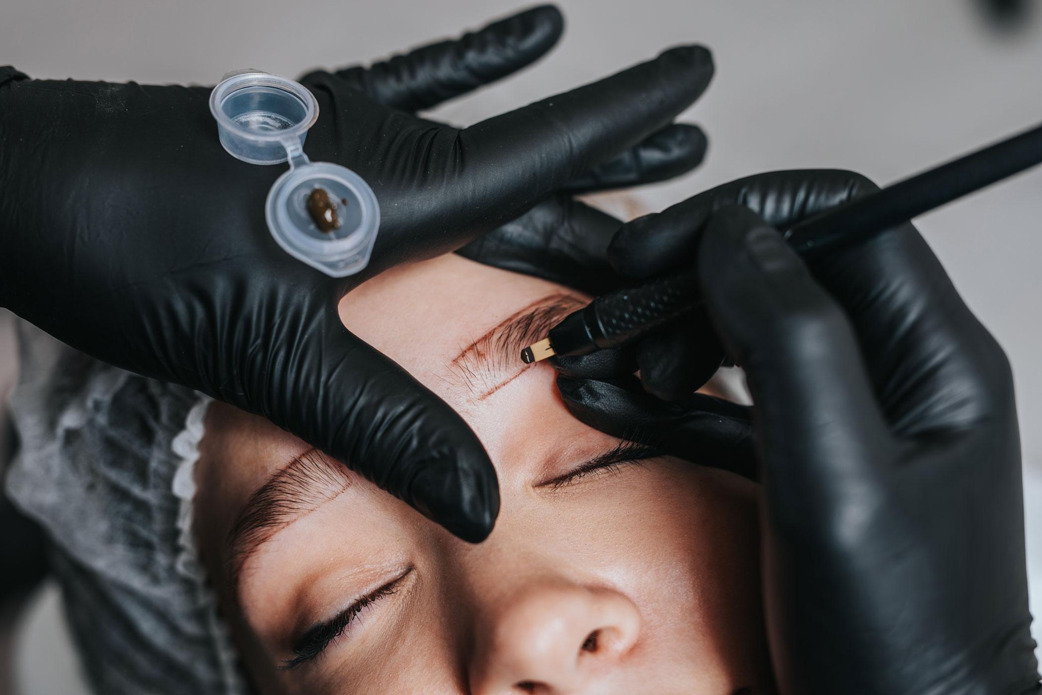 Artist preparing a client's brows for treatment